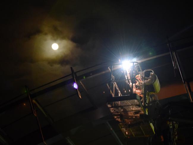 夜幕下的钢铁之美：高速公路夜间电焊作业与灯光美景